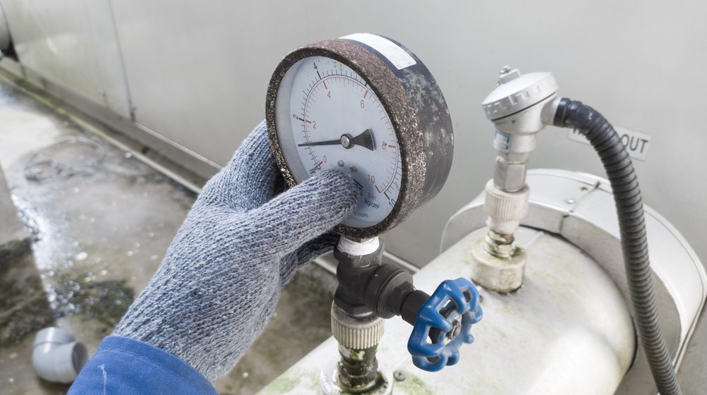 pressure gauge being inspected by gloved hand